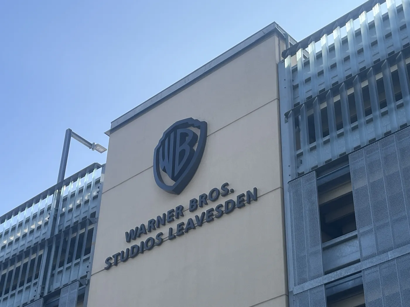 Studio building wall with the Warner Bros. Studios Leavesden name against a blue sky