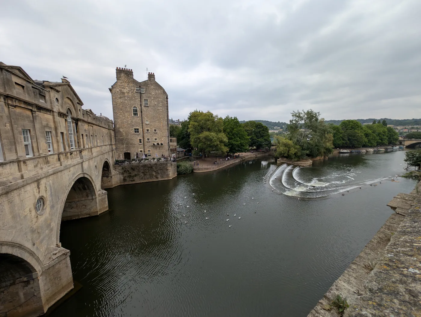 Pulteney Bridge with shops built across it above the curved weir on the River Avon