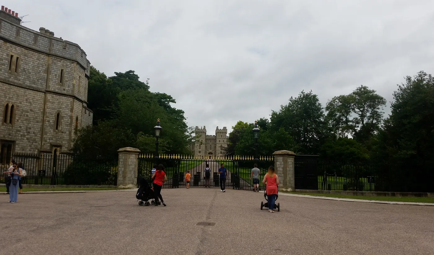 Windsor Castle walls and gateway at the top of the Long Walk, framed by trees